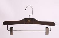 Dark brown wooden hanger with clips for clothes shop